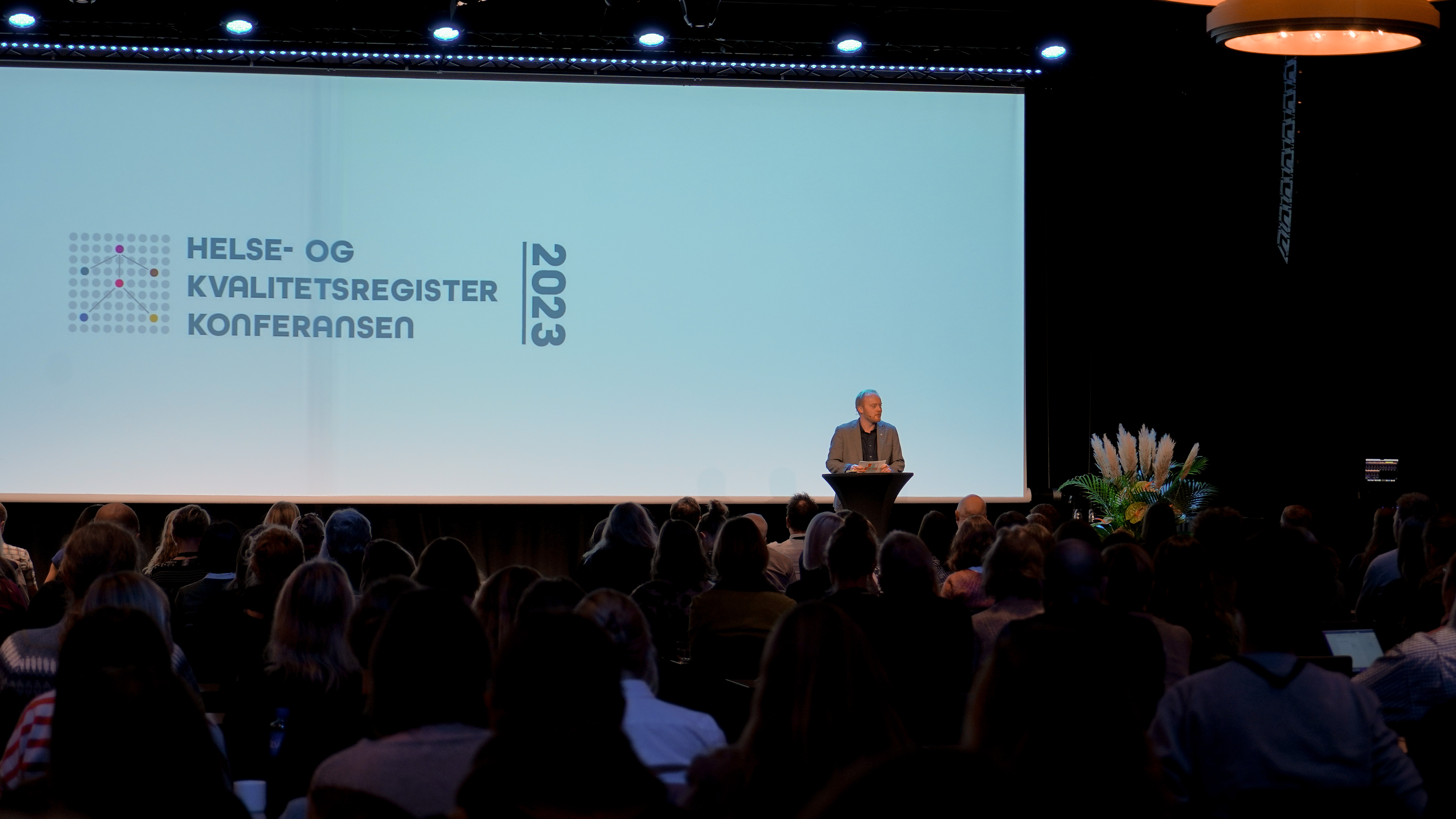 En person på en scene med en folkemengde som ser på