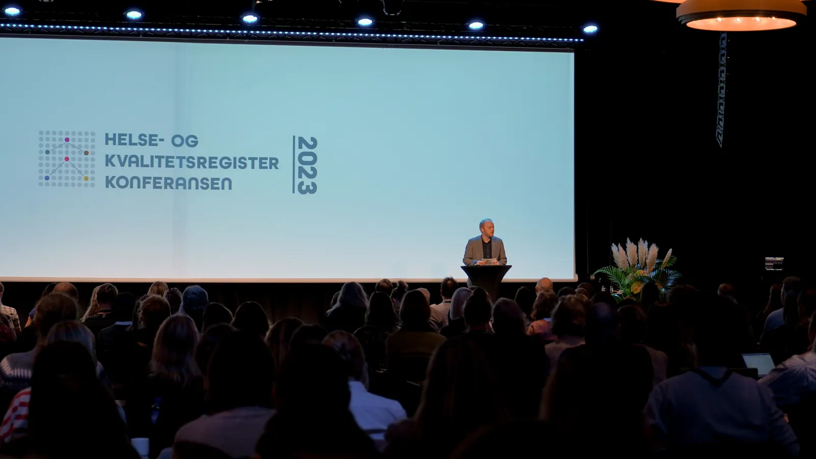 En person på en scene med en folkemengde som ser på