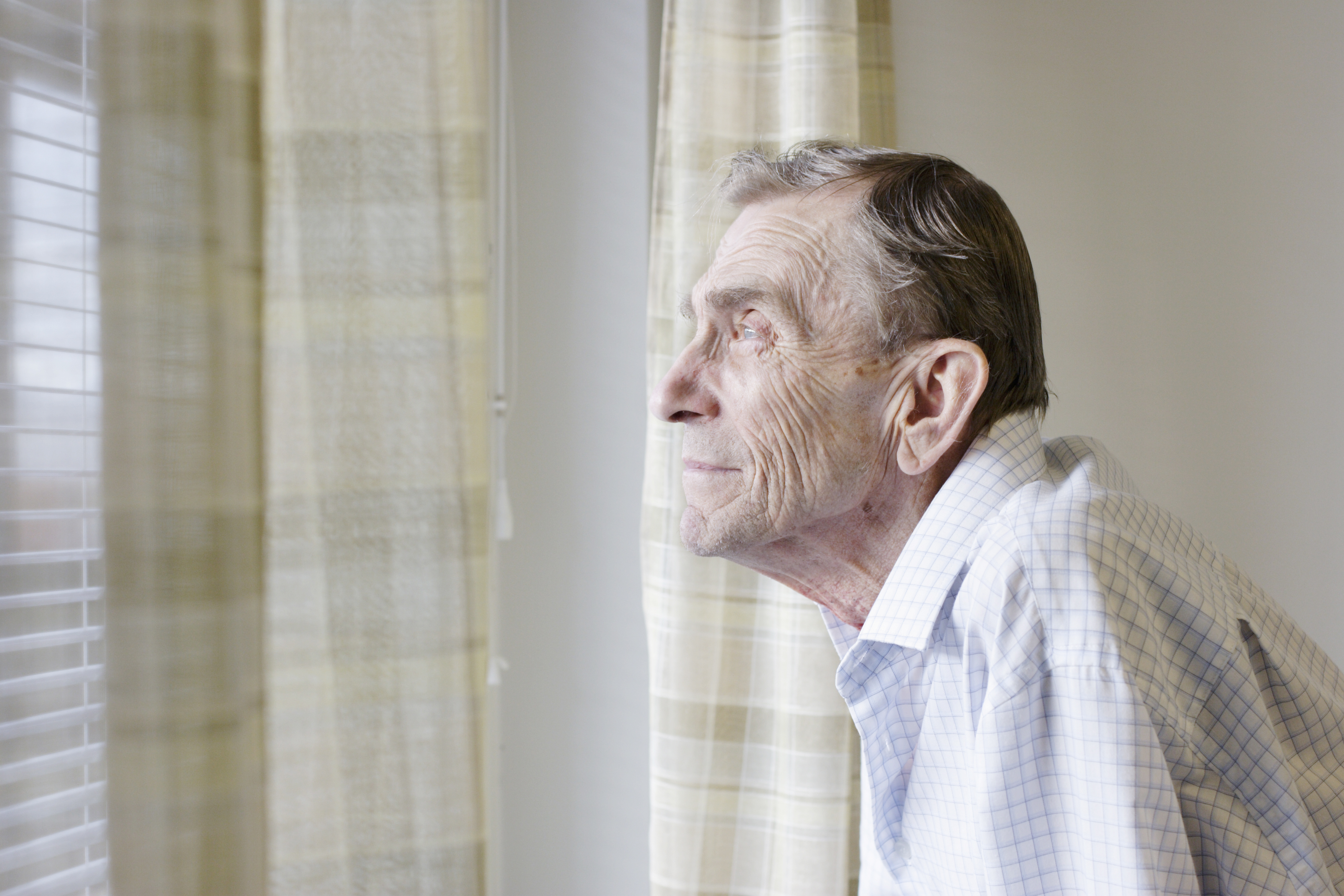 An older man looking out a window