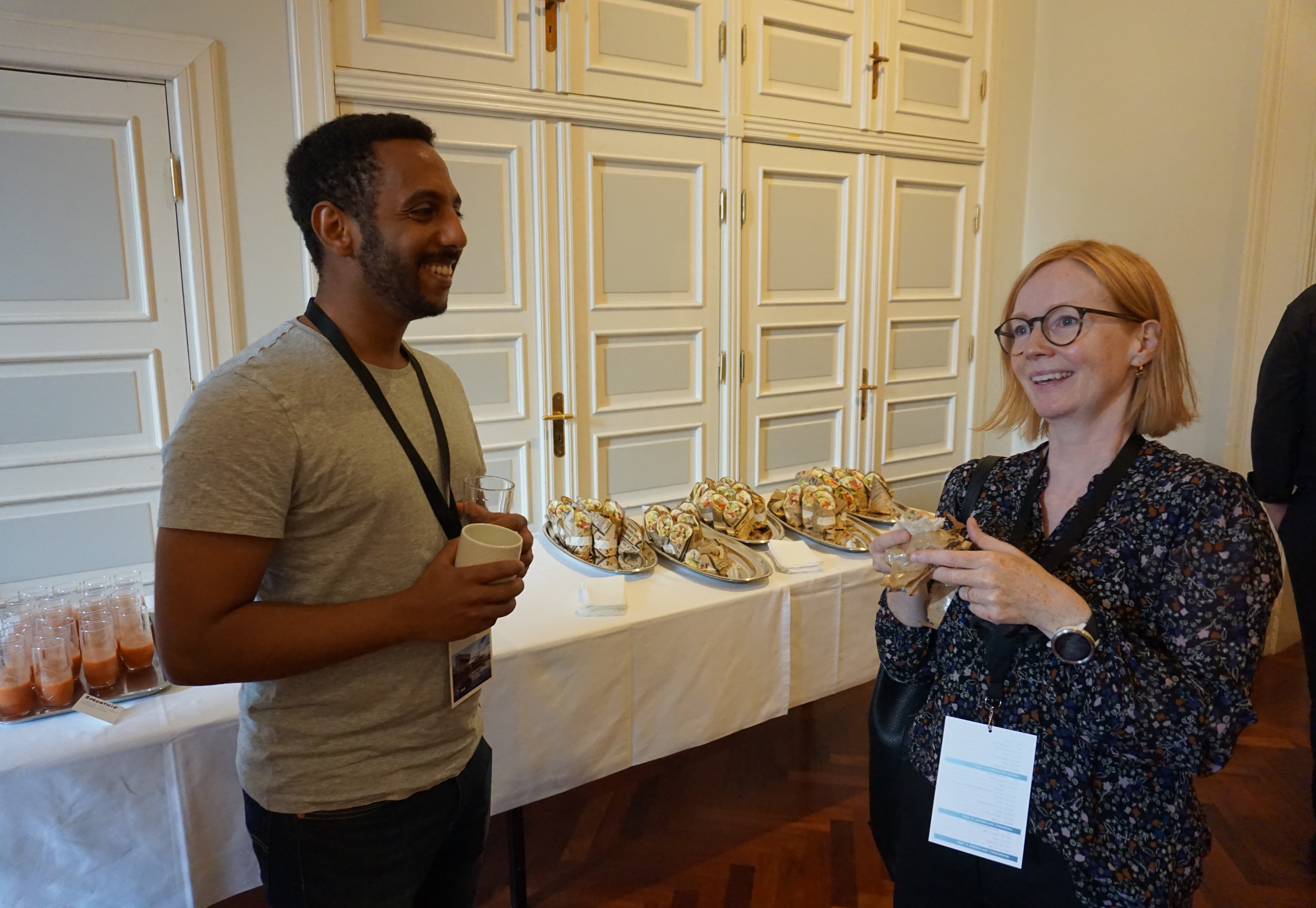 A man and a woman standing at a table with food on it