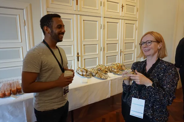A man and a woman standing at a table with food on it