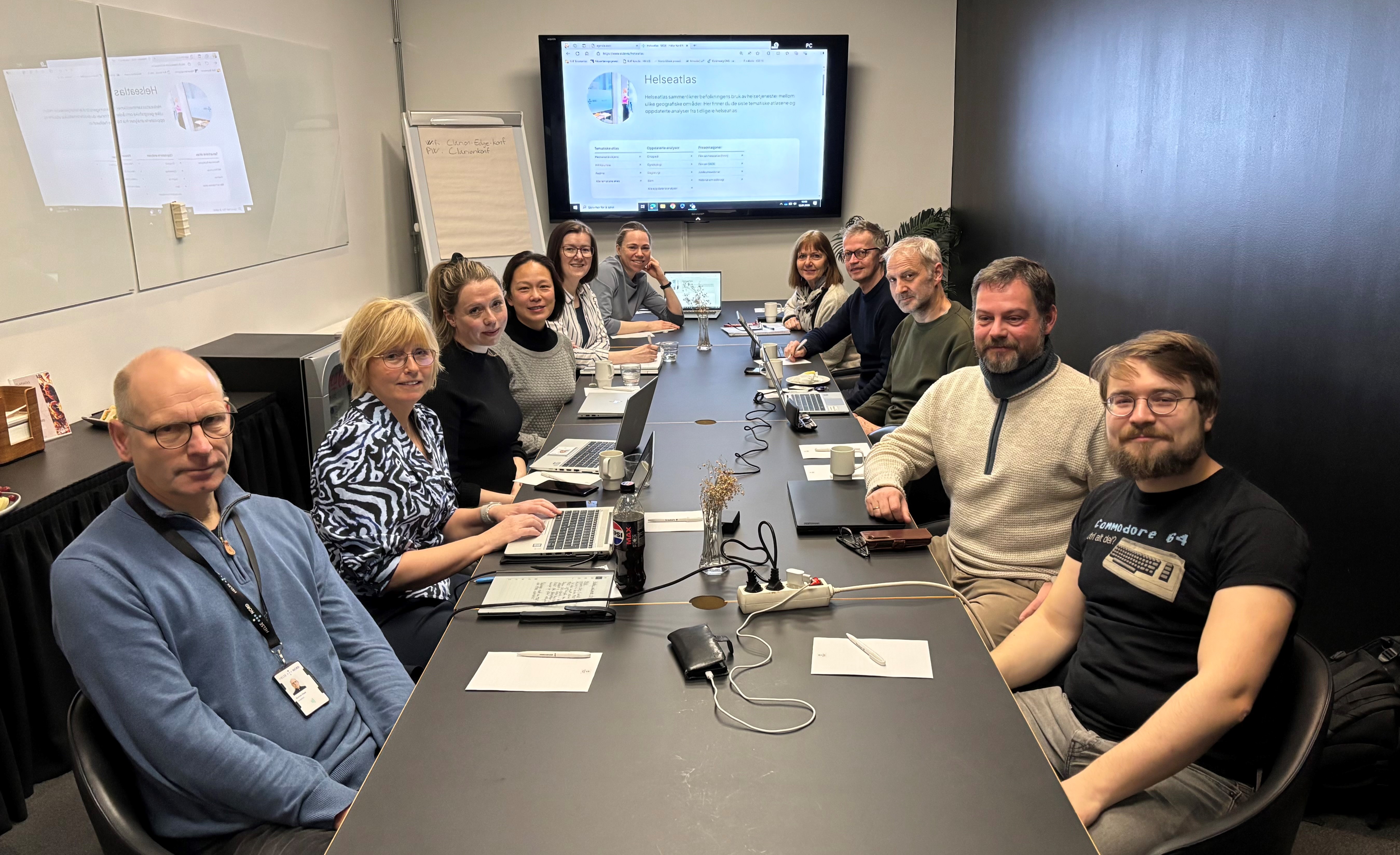 A group of people sitting around a table with computers