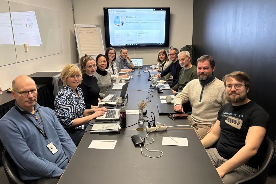 A group of people sitting around a table with computers