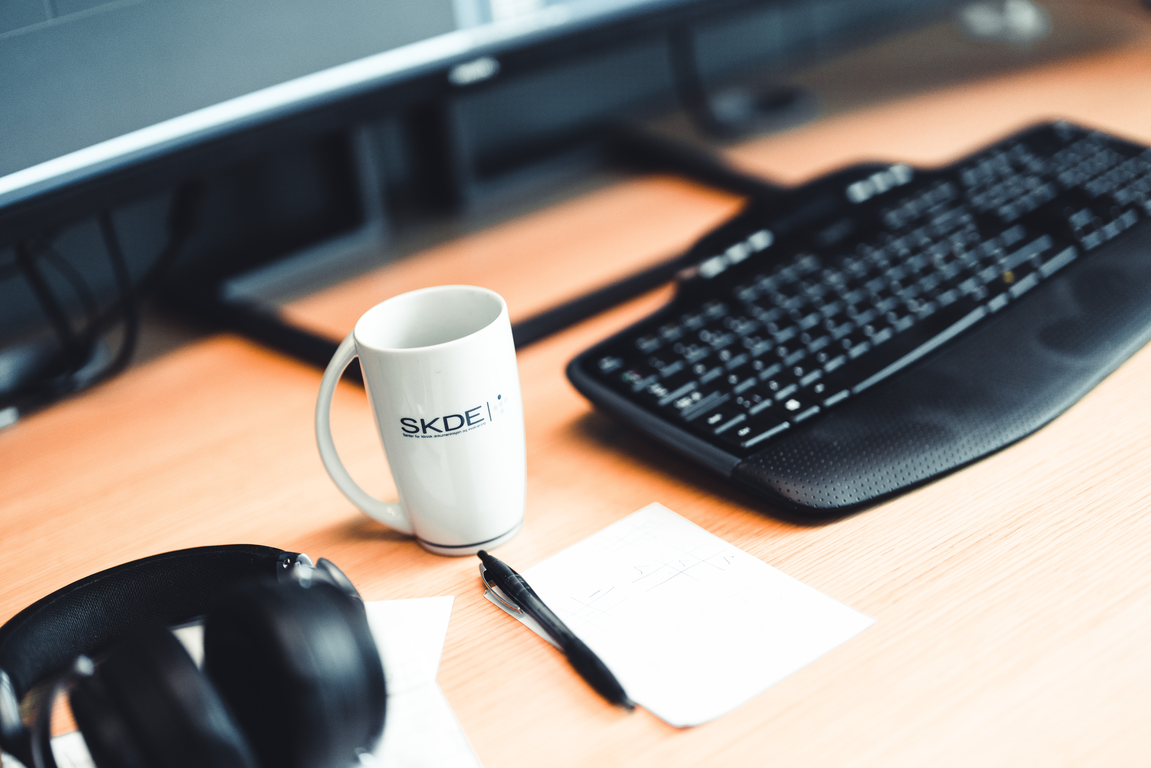 En kaffekopp og et tastatur på et skrivebord