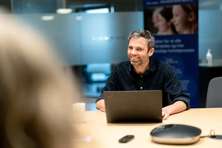 A man sitting at a table with a laptop