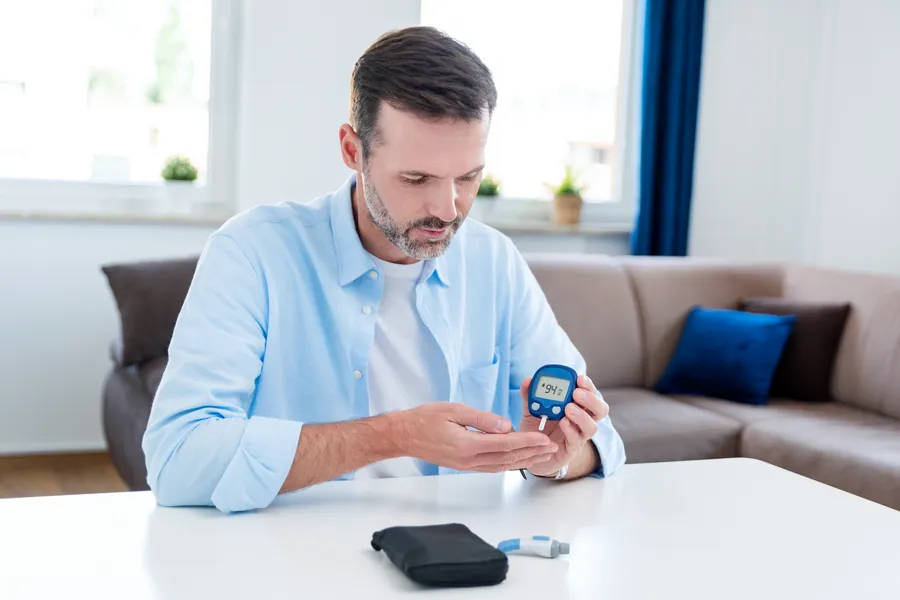 A man sitting at a table measuring bloodsugar