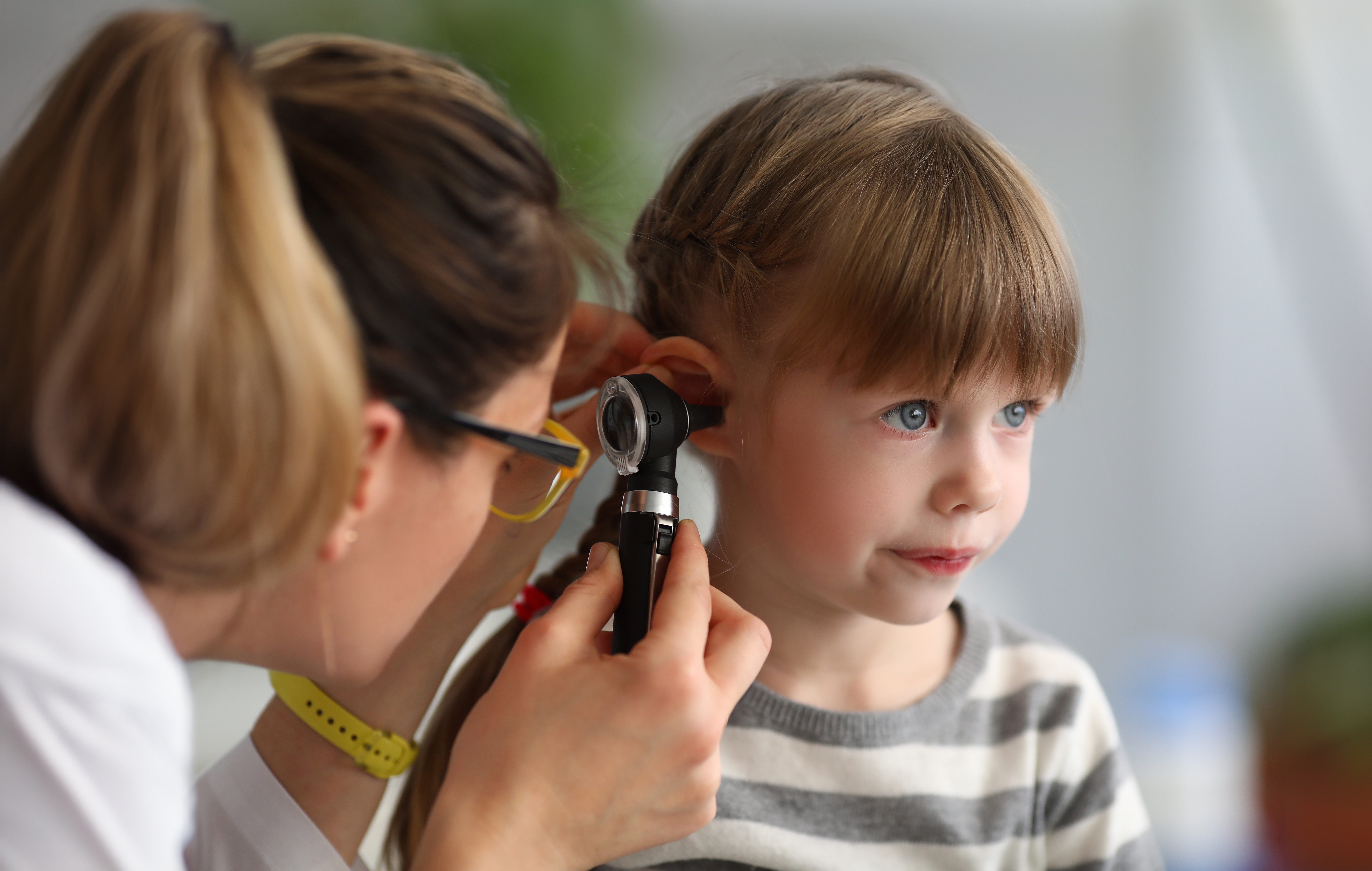 Female doctor examining a young girls ear