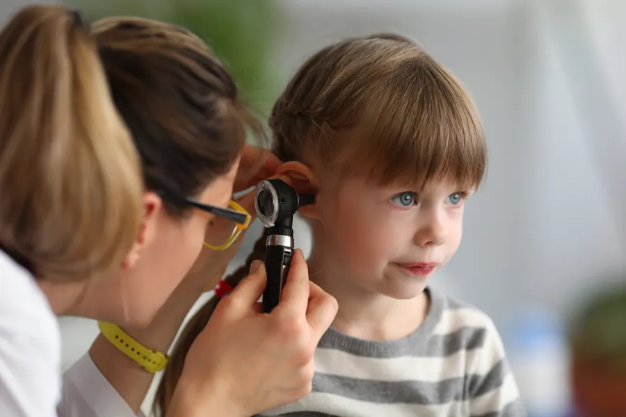 Female doctor examining a young girls ear