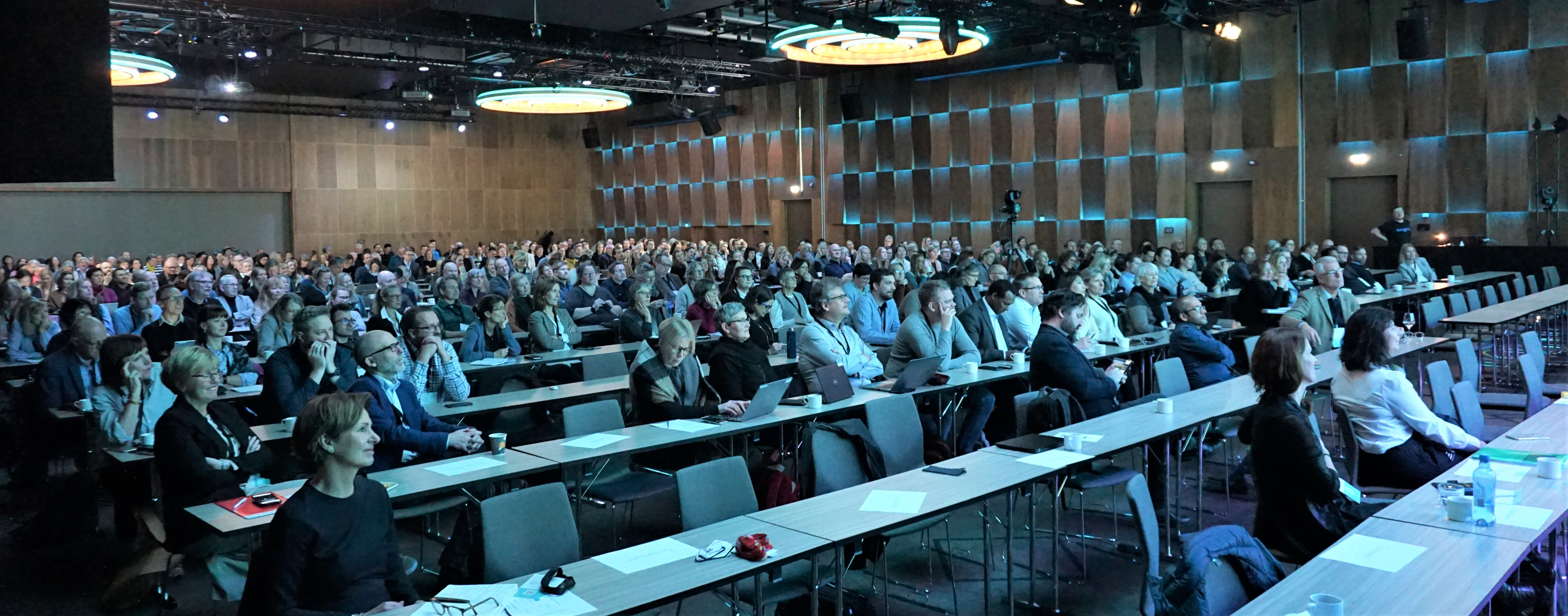 En gruppe mennesker som sitter i et konferanserom