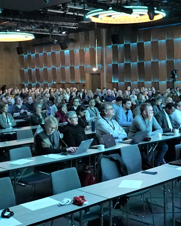 En gruppe mennesker som sitter i et konferanserom
