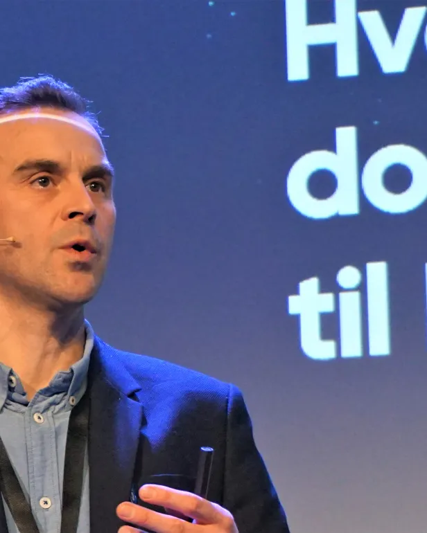 En mann som snakker inn i en mikrofon