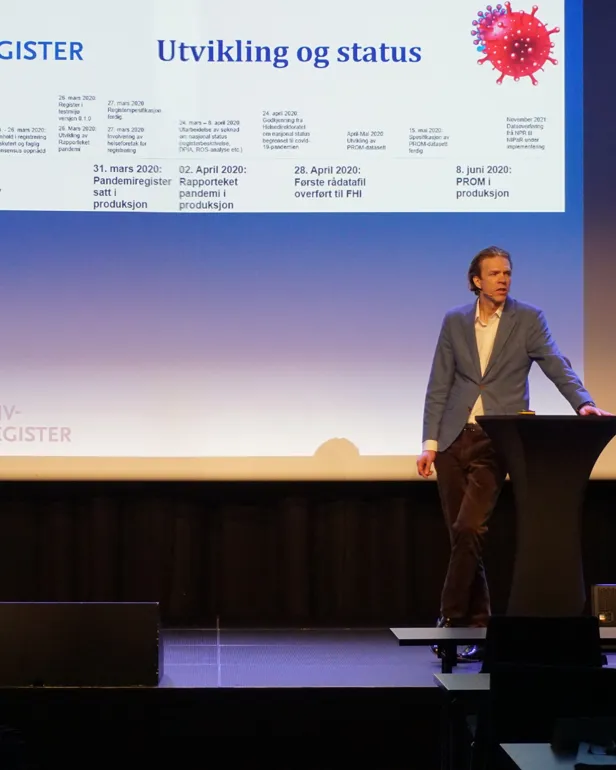 En mann holder framlegg på konferansen