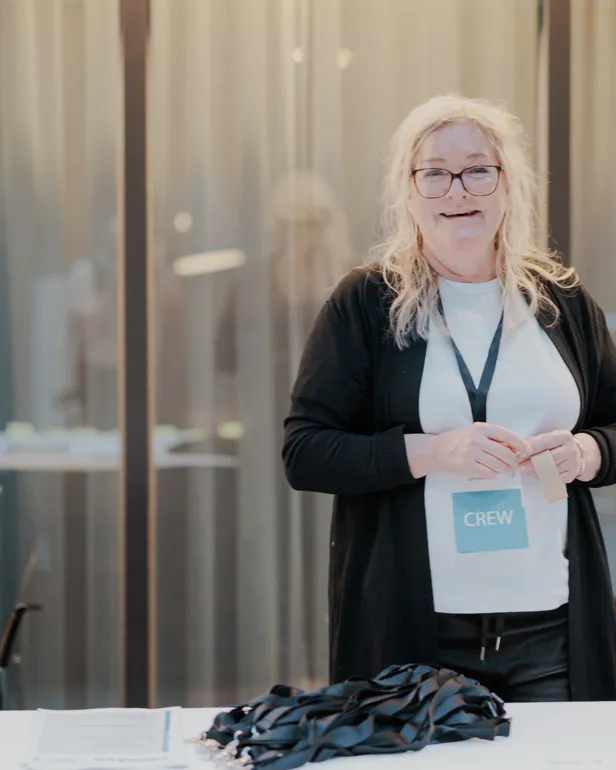 En kvinne som står foran et bord med en mikrofon