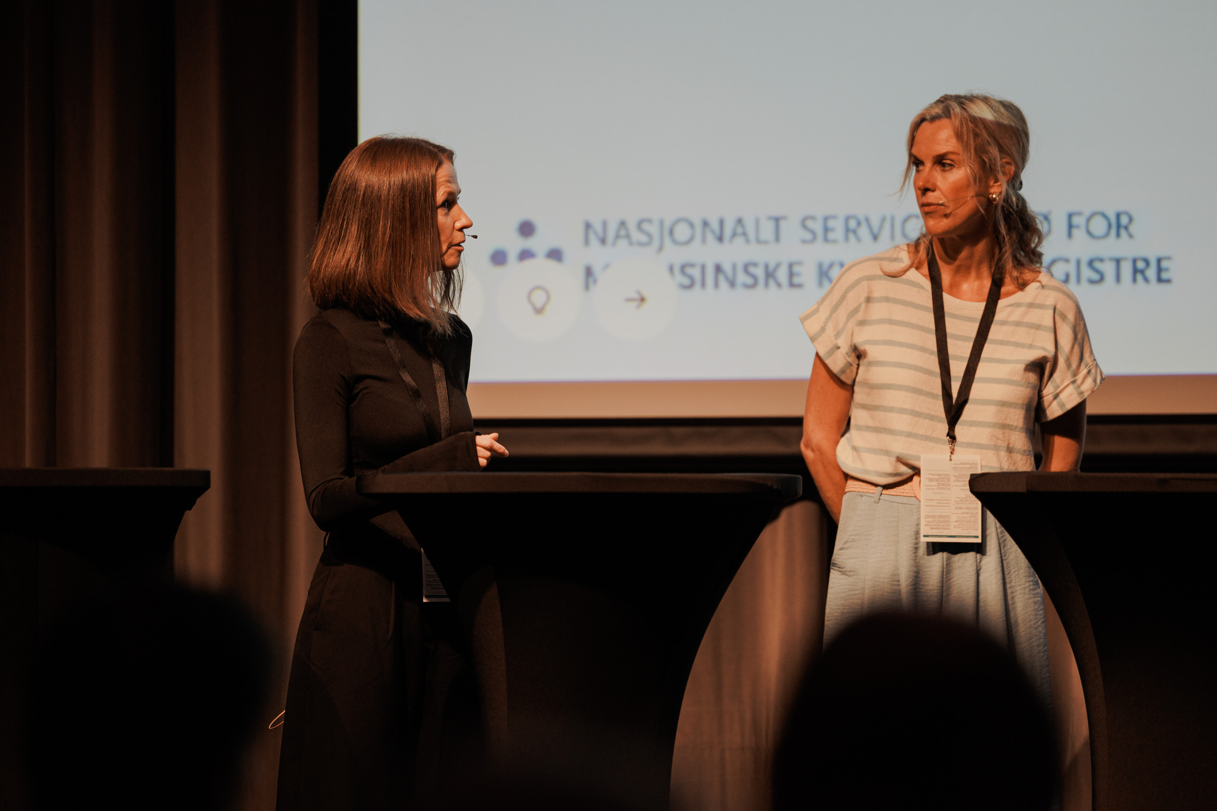 En kvinne som står ved siden av en kvinne som sitter ved et piano