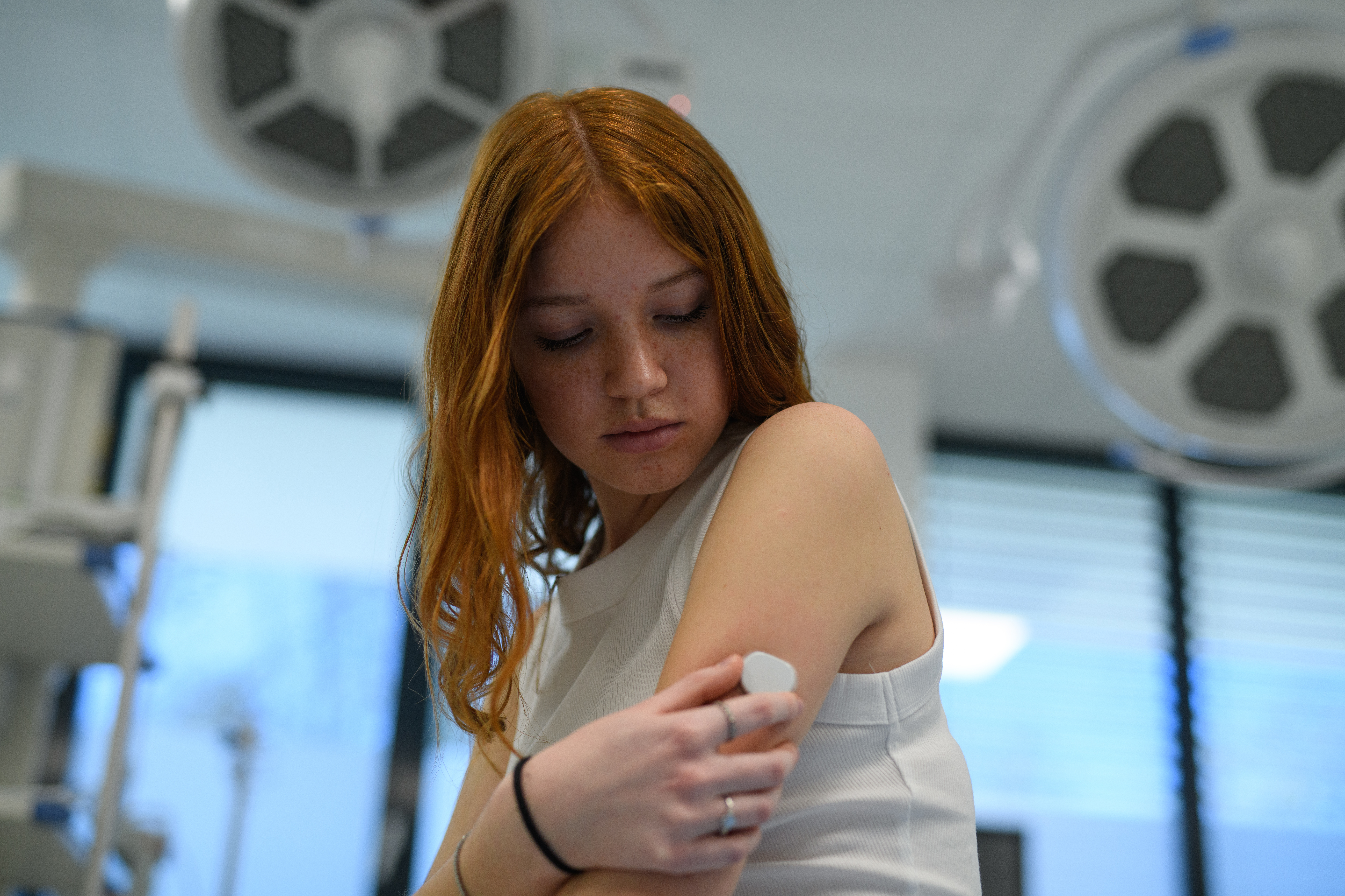 Girl with a blood glucose monitor on her arm